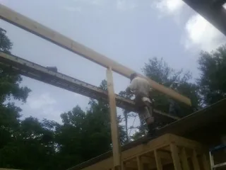 Carpenter setting a ridge beam over a new addition frame — Ice Dam Removal by Roofing Brothers in Aragon