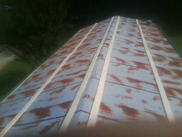 Rusted metal roof panels with new wood purlins before replacement — Storm Damage Roof Repair in Aragon by Roofing Brothers