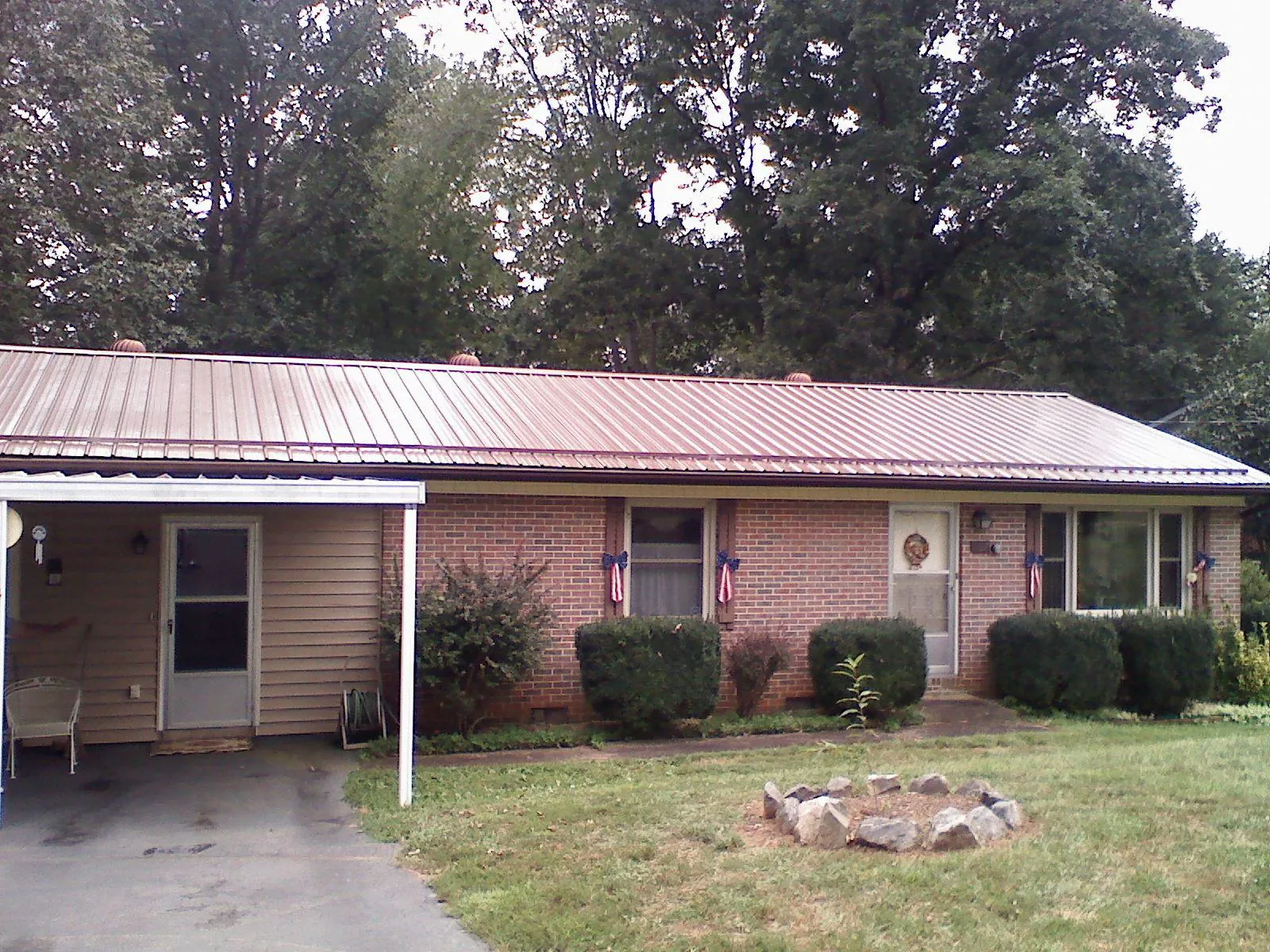 Bronze metal roof and carport on a brick ranch home — Roof Repair work by our crew in Aragon